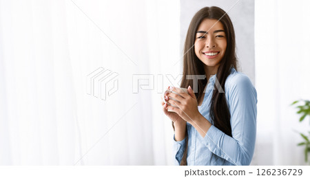 Morning Coffee Concept. Beautiful Young Korean Woman Holding Cup With Hot Drink, Standing Near Window At Home, Having Day Off, Smiling And Looking At Camera, Enjoying Weekend Relax, Free Space Morning Coffee Concept. Beautiful Young Korean Woman Holding Cup With Hot Drink, Standing Near Window At Home, Having Day Off, Smiling And Looking At Camera, Enjoying Weekend Relax, Free Space 126236729
