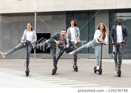 Modern Generation Concept. Five trendy teenagers having fun, riding electric push scooters, fooling around 126236746