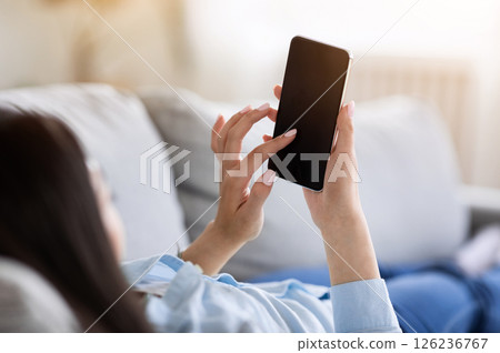 Mockup Image Of Unrecognizable Woman Using Smartphone With Black Screen At Home, Relaxing On Couch With Device, Copy Space Mockup Image Of Unrecognizable Woman Using Smartphone With Black Screen At Home, Relaxing On Couch With Device, Copy Space 126236767