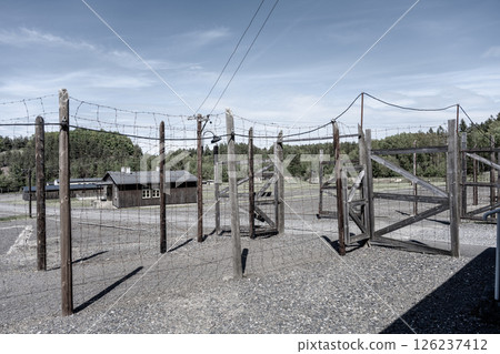 A historic prison complex in Lesetice, Czechia, commemorates the victims of communism. The site features barbed wire fencing and wooden structures, evoking a somber reflection on the past. A historic prison complex in Lesetice, Czechia, commemorates the victims of communism. The site features barbed wire fencing and wooden structures, evoking a somber reflection on the past. 126237412