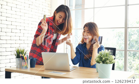 Two friends shopping using credit card online shopping on website laptop e-commerce website with smiling face, happiness. Happy asian women using laptop shopping online buy, payment newnormal concept 126239417