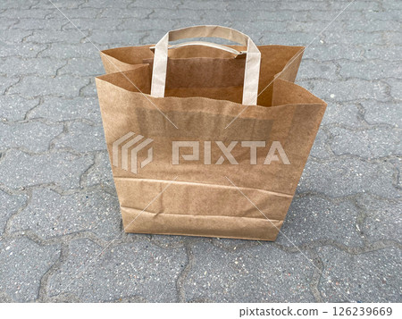 Paper eco-friendly biodegradable grocery bag stands on the pavement on the street, caring for the environment 126239669