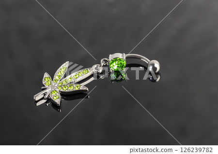 Belly button earrings with stones and a pendant in the shape of cannabis leaves. Belly button earrings with stones and a pendant in the shape of cannabis leaves. 126239782