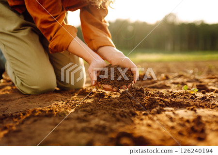Close-up of experienced woman farmer's hands holding fresh soil. Concept of growing lard, ecology. 126240194