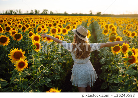 Beautiful woman posing in a field of sunflowers in a dress. Fashion, lifestyle, travel concept. 126240588