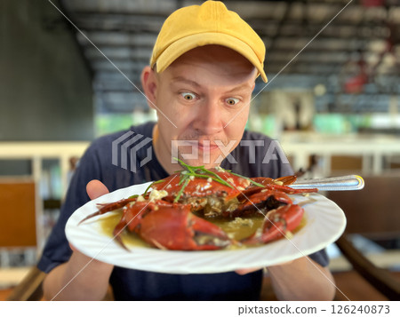 happy man showing crab on plate 126240873