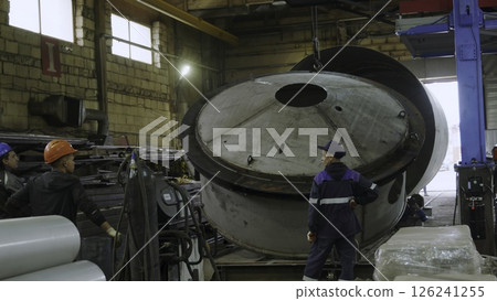 An Industrial Workshop Featuring Heavy Machinery Alongside Skilled Workers in Action. Media 126241255