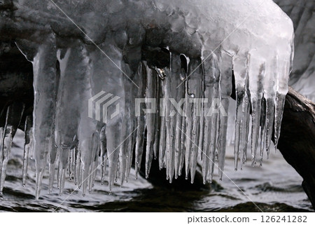 Icicles on the lakeside created by wave spray Icicles on the lakeside created by wave spray 126241282