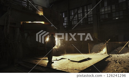 An Industrial Worker Skillfully Engaged in the Art of Casting Metal in a Vibrant Factory Environment. Stock Clip 126241296