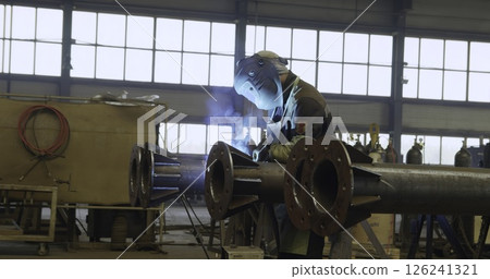 An Industrial Worker Wearing Protective Gear in a Workshop Environment While Working. Media An Industrial Worker Wearing Protective Gear in a Workshop Environment While Working. Media 126241321