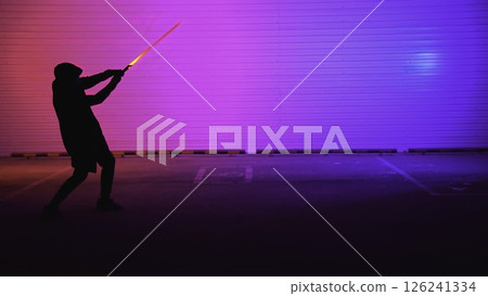 A striking neon silhouette illuminated by light in a bustling urban environment at night. Media A striking neon silhouette illuminated by light in a bustling urban environment at night. Media 126241334