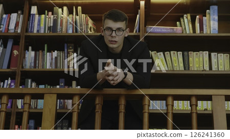 A Young Scholar in a Library Setting Deeply Contemplating and Engaging with Knowledge. Media A Young Scholar in a Library Setting Deeply Contemplating and Engaging with Knowledge. Media 126241360