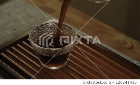 Pouring tea into a textured glass cup creates a calm atmosphere and showcases handcrafted luxury. Media Pouring tea into a textured glass cup creates a calm atmosphere and showcases handcrafted luxury. Media 126241416