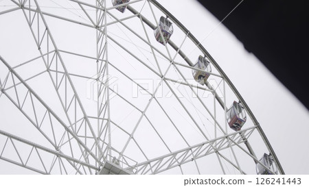 Ferris wheel rotating under cloudy sky. Action Ferris wheel rotating under cloudy sky. Action 126241443