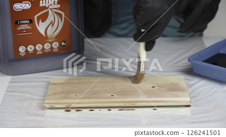 A person is currently painting a piece of wood using a brush. Creative 126241501