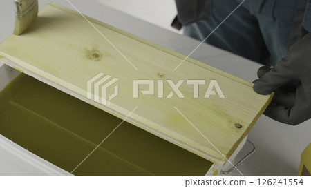 An artisan paints wood, cleans honeycomb, showcasing dedication. Creative 126241554