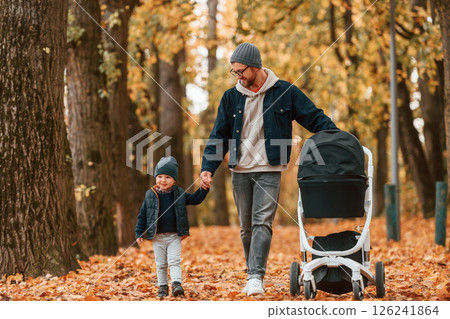 With pram. Father and young son is together outdoors at daytime 126241864