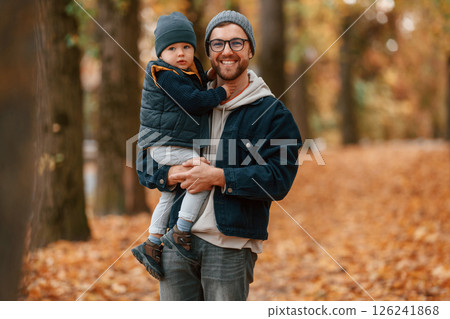 Holding son and smiling. Father and young son is together outdoors at daytime 126241868