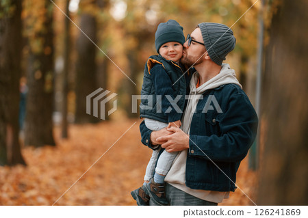 Holding son and smiling. Father and young son is together outdoors at daytime 126241869
