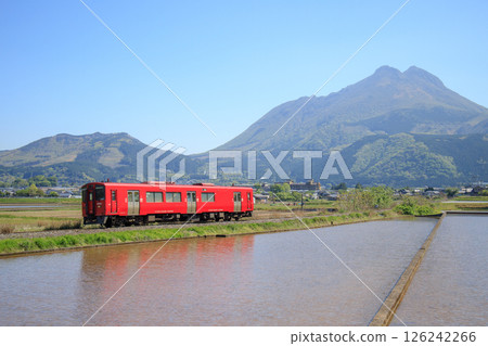 Spring haze over Mount Yufu and a red train (JR Kyushu Kiha 220 series) 126242266