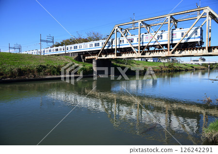 Tobu Urban Park Line 8000 series train crossing the retro truss bridge with a water reflection 126242291
