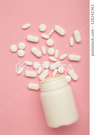 Assorted pharmaceutical medicine pills and bottle on pink background. Vertical photo Assorted pharmaceutical medicine pills and bottle on pink background. Vertical photo 126242361