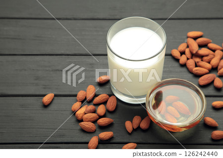Almond milk and oil on black wooden background. Top view 126242440