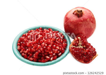 Half-cut pomegranate with seeds in plate isolated on white background. Top view 126242529