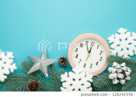 Alarm clock with white snowflakes and fir tree on blue background. Alarm clock with white snowflakes and fir tree on blue background. 126242556
