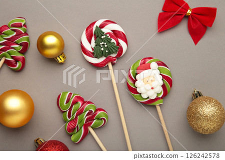 Christmas Candy with christmas ball on grey background. Sweet lollipop 126242578