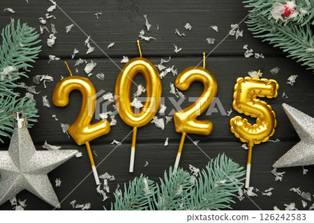 Holiday background Happy New Year 2025. Numbers of year 2025 made by gold candles with fir tree on black wooden background. Holiday background Happy New Year 2025. Numbers of year 2025 made by gold candles with fir tree on black wooden background. 126242583