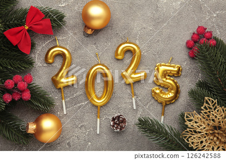 Merry Christmas and Happy New Year 2025. Golden candles numbers 2025 with green balls on grey background. Top view Merry Christmas and Happy New Year 2025. Golden candles numbers 2025 with green balls on grey background. Top view 126242588