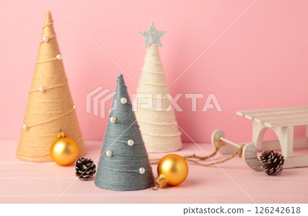 Handmade Christmas trees with gift on pink background. Yarn wrapped cone trees. DIY concept. Handmade Christmas trees with gift on pink background. Yarn wrapped cone trees. DIY concept. 126242618
