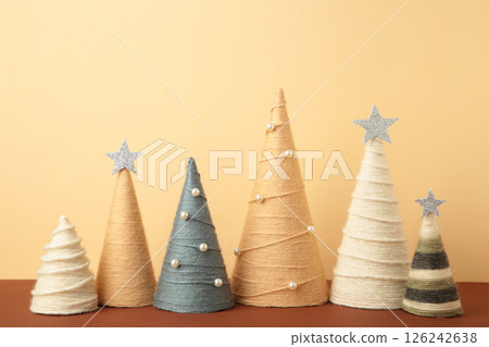 Handmade Christmas trees on beige background. Yarn wrapped cone trees. DIY concept 126242638