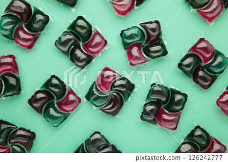 Gel capsules with laundry detergent on mint background Gel capsules with laundry detergent on mint background 126242777