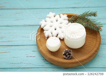 Cold protecting winter cream concept. Jar cosmetics with snowflakes and fir tree branches on blue wooden background. Winter seasonal skin care 126242799