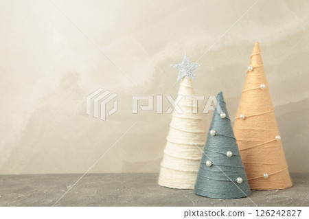 Handmade Christmas trees on light background. Yarn wrapped cone trees. DIY concept. Space for text 126242827