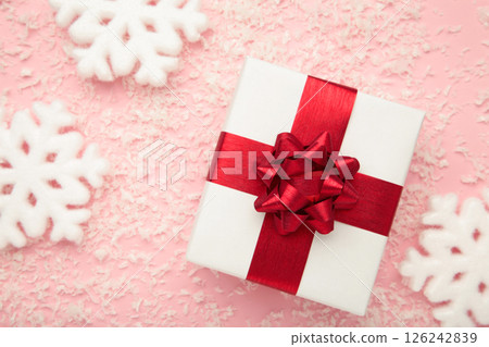 Merry Christmas and Happy Holidays. White Christmas gifts with white snowflakes on pink background. Top view Merry Christmas and Happy Holidays. White Christmas gifts with white snowflakes on pink background. Top view 126242839