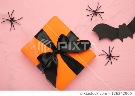 Halloween decoration concept. Artificial spider web decoration with spiders and gift on pink background. top view Halloween decoration concept. Artificial spider web decoration with spiders and gift on pink background. top view 126242960