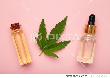 Glass bottles with CBD oil, thc tincture, hemp leaves on pink background. Cosmetics CBD hemp oil Glass bottles with CBD oil, thc tincture, hemp leaves on pink background. Cosmetics CBD hemp oil 126243512