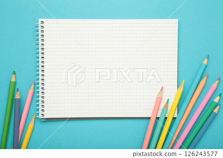 Open notebook with colorful pencil on blue background. Open notebook with colorful pencil on blue background. 126243577