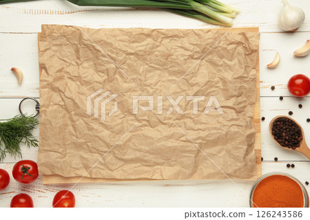 Baking paper with green onions, garlic, spices and tomatoes on white wooden background. Cooking concept 126243586