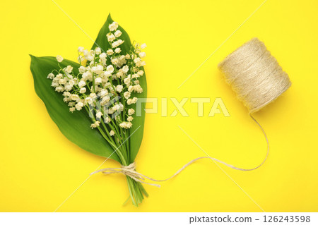 May flowers. Bouqet of lily of the valley flowers on yellow background. May flowers. Bouqet of lily of the valley flowers on yellow background. 126243598