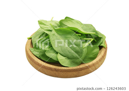 Spinach leaves in a wooden plate isolated on white. 126243603