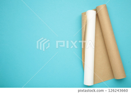 Rolls of white and brown baking paper on blue background 126243660