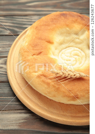 Georgian traditional bread flatbread on brown wooden background. Vertical photo Georgian traditional bread flatbread on brown wooden background. Vertical photo 126243677