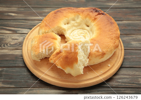 Georgian traditional bread flatbread on brown wooden background. Georgian traditional bread flatbread on brown wooden background. 126243679