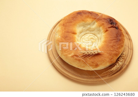 Georgian traditional bread flatbread on beige background. Georgian traditional bread flatbread on beige background. 126243680