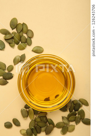 Pumpkin seed oil and seeds on beige background. Vertical photo Pumpkin seed oil and seeds on beige background. Vertical photo 126243706