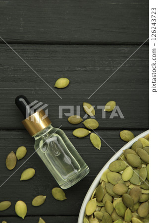 Pumpkin seed oil on black wooden background. Top view 126243723